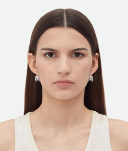 Close-up of model wearing silver C-shaped earrings with light purple enamel layers