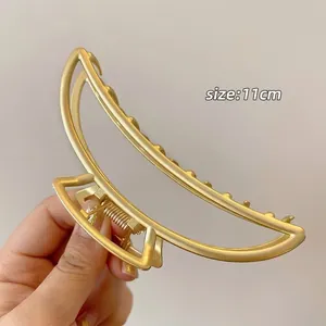 Close-up of 11cm gold minimalist hair claw clip featuring a sleek semi-moon metal design