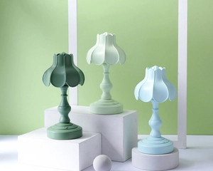 Dettaglio di luci notturne a LED retrò a forma di petalo in verde e blu su piedistalli