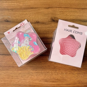 Detail of pink star-shaped hair brush featuring flowing star glitter and unicorn design