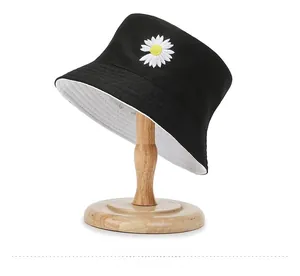 Detail shot of a reversible cotton bucket hat with a small daisy embroidery pattern
