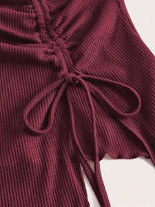 Detailed close-up of wine red waffle knit fabric with decorative drawstring accent