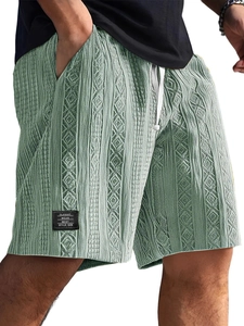 Detailed close-up of light green knit shorts featuring cable texture and classic patch