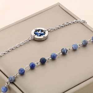 Detail of silver compass pendant with star and blue beaded stone strand necklace