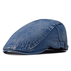 Detail of blue denim flat cap showing quilted texture and adjustable metal side buckle