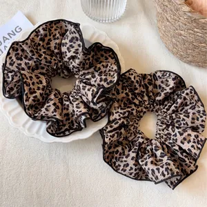 Set di due elastici per capelli leopardati su un piatto decorativo in porcellana bianca