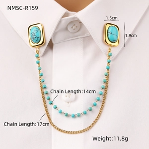 Detail of oval turquoise collar pin with golden chains and measurements on a white shirt