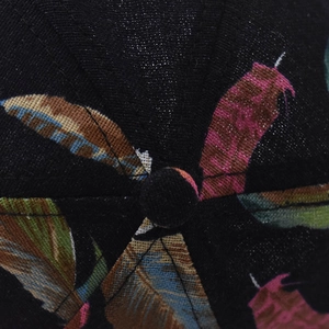 Detailed macro view of cotton baseball cap crown featuring colorful feather print and stitching