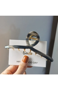 Detail of blue marble acetate hair claw clip with golden metal teeth and spring