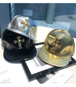 Detail of leather baseball caps with shiny snakeskin texture and rhinestone cross