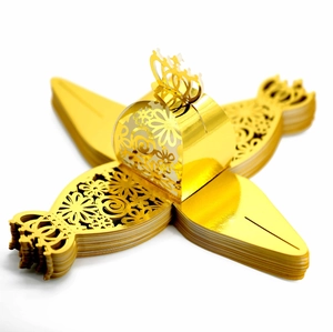 Detail of laser-cut gold wedding favor boxes with crown top and floral texture