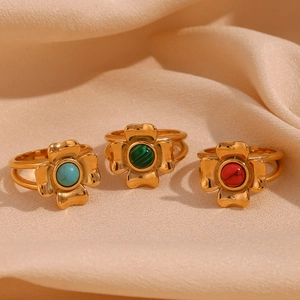 Detailed view of 18K gold plated clover rings with red, blue, and green natural stones