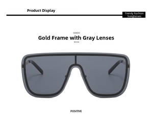 Front view of oversized one-piece sunglasses with gold metal frame and grey lenses