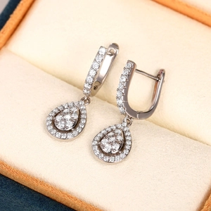 Detailed macro view of silver drop earrings with white AAA cubic zirconia in a jewelry box