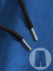 Detail of blue sports shorts showing black woven drawstring with silver metal tips