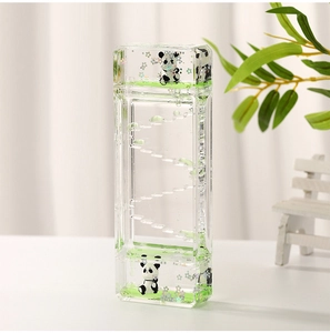 Macro detail of floating panda figures and glitter inside green liquid oil hourglass