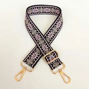 Detail of 3.8cm wide woven canvas strap with pink diamond patterns and gold metal clips