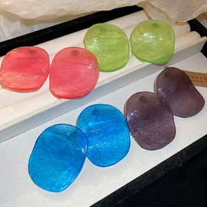 Macro shot of colorful resin oval earrings with horizontal brushed texture details