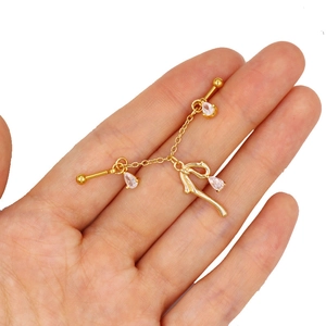 Detail of gold ear cartilage chain featuring a teardrop zircon and butterfly pendant