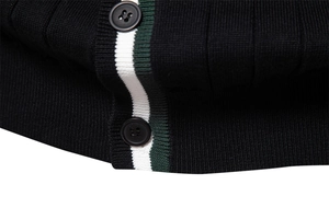 Dettaglio dei bottoni del cardigan nero e bordo a righe con trama in maglia di lusso