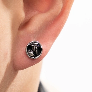 Punk style black round stainless steel stud earring with embossed pattern on ear lobe