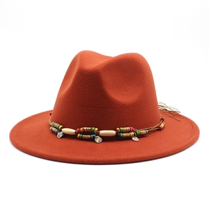 Détail du ruban perlé ethnique avec pendentifs métalliques sur un chapeau fedora en laine