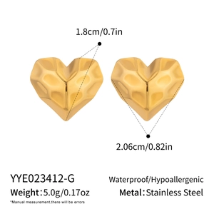 Detailed view of heart stud earrings showing faceted texture and measurement scale