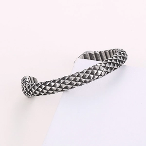Close-up of vintage silver steel open bangle with detailed dragon scale texture
