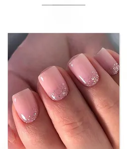 Macro detail of nude pink gradient nails with silver glitter tips in short square shape