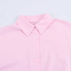 Close-up of pink shirt collar showing fabric texture and white resin buttons