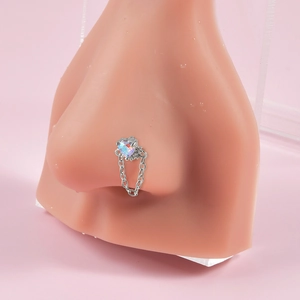 Detail of silver nose ring with iridescent heart gem and chain on a silicone model