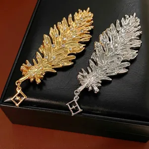 Luxurious feather brooch set with crystal accents in gold and silver plating