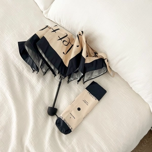 Detail of khaki and black umbrella with matching storage pouch and frosted handle