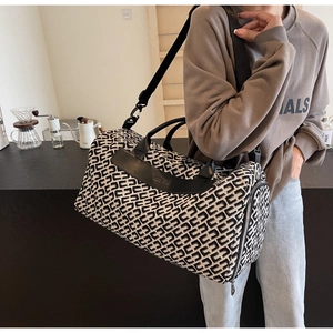 Détail d'un grand sac de voyage élégant pour femme avec un motif géométrique tissé