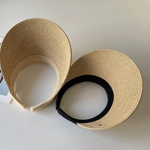 Detail of woven straw sun visor headbands with minimalist texture and open-top design