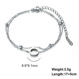Detail of double-layer stainless steel bracelet with letter pendant and lobster clasp