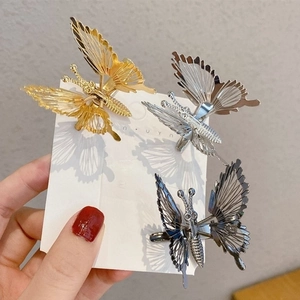 Set of four hollow metal butterfly hair clips in gold, silver, black and grey tones