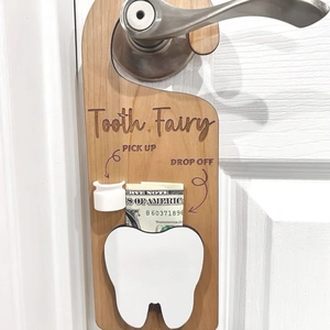 Detail of wooden tooth fairy door hanger with pocket and pickup arrows hanging on handle