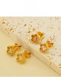 Dettaglio di orecchini a stella placcati oro 18K con zirconi rosa e bianchi su pietra