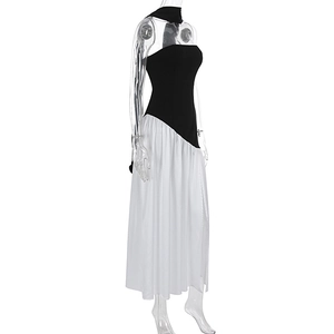 Detail view of the asymmetric black and white patchwork seam on a slim fit maxi dress