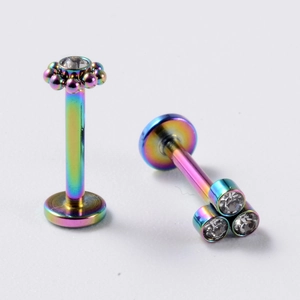 Vue macro de piercings labret dégradés colorés avec des zircons brillants incrustés