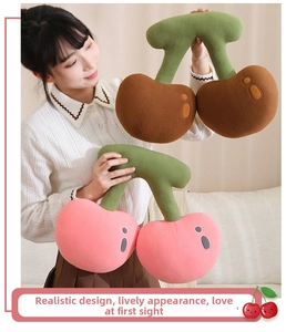 Close-up of soft plush cherry-shaped cushions in pink and brown with green stems