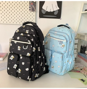Detail showing the multi-pocket structure and bear print on stylish student backpacks