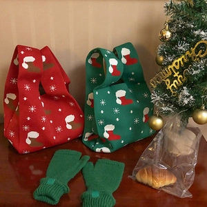 Detailed view of red and green knit tote bags with snowflake patterns and matching gloves