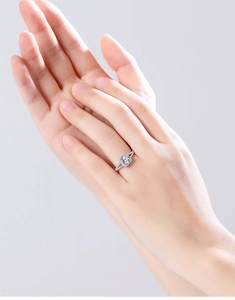 Detailed close-up of a silver ring with a large round-cut moissanite and pave accents