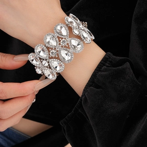 Détail d'un bracelet argenté brillant avec strass et gouttes d'eau sur le poignet
