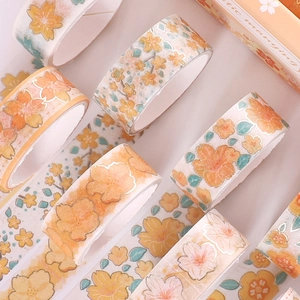 Detailed view of warm orange cherry blossom washi tape with gold foil stamping accents