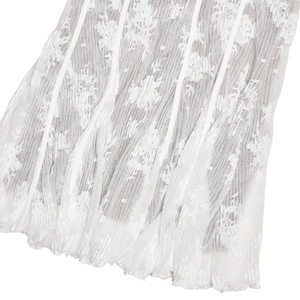 Detailed close-up of white lace fabric with floral patterns and vertical pleated texture