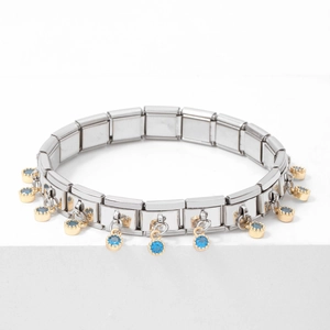 Detail of silver modular link bracelet with gold charms and blue round gemstones