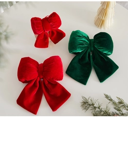 Close-up of premium red and green velvet Christmas bows on a festive holiday desktop